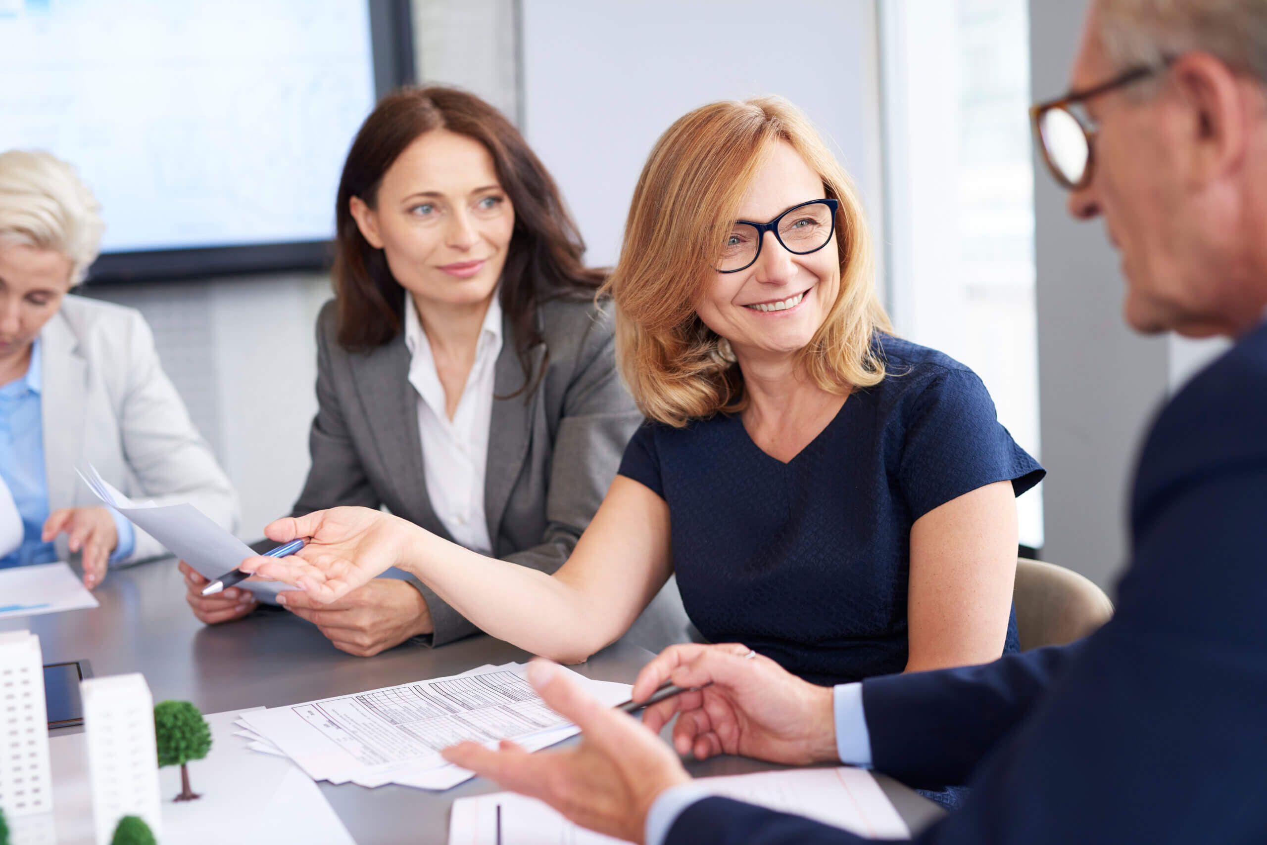 Business executives speaking and smiling to one another