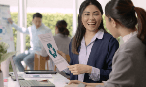 A person presenting to a coworker their document about recycling.
