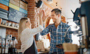Two people celebrating in a restaurant environment.