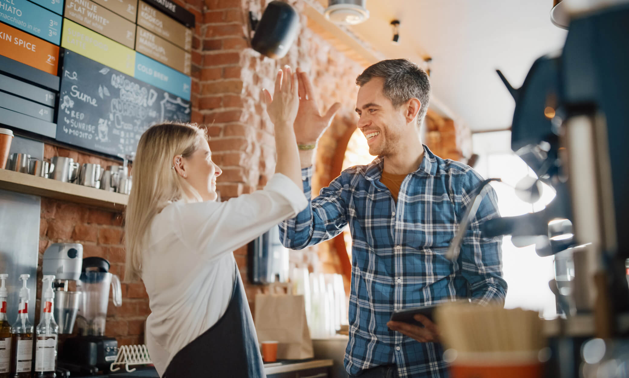 Two people celebrating in a restaurant environment.